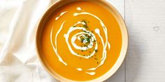 a bowl of carrot soup with cream on top