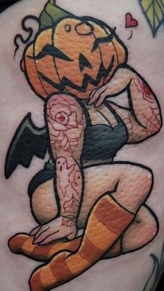 a woman's thigh with a tattoo on it and an image of a pumpkin