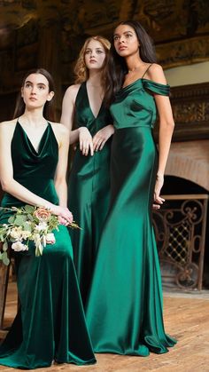 three women in green dresses standing next to each other and one is holding a bouquet