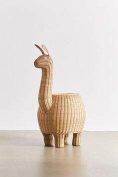 an animal made out of wicker sitting on top of a white floor next to a wall