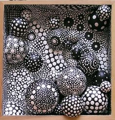 black and white balls in a wooden box with polka dots on the outside, inside