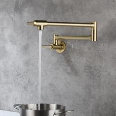 the brass faucet is pouring water into a pot