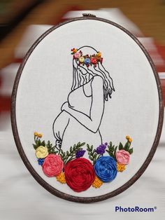 a woman with flowers in her hair is shown on a white background and has an embroidery hoop