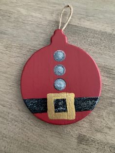 a red ornament hanging from a wooden table