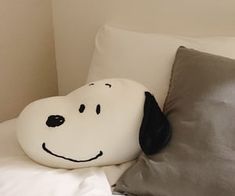 a pillow with a dog's face on it sitting on top of a bed