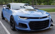 a blue chevrolet camaro parked in a parking lot