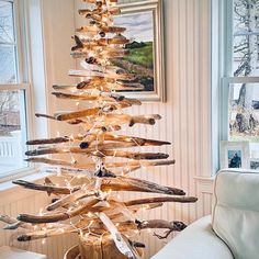 a christmas tree made out of driftwood and lights in the corner of a living room