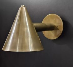 a wall light with a cone shaped shade on it