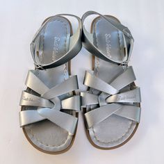 New Without Tags Or Box. Metallic Silver Color. The Salt Water Original Sandal, The First To Debut From Walter Hoy’s Workshop In 1944, Is Defined By Its Hand-Crafted, Non-Slip, Molded Rubber Sole And Scuff-Resistant, Water-Friendly Genuine Leather Upper. They Clean Up Easily, Come With Rust-Proof Brass Buckles And Are Made For In-And-Out-Of-Water Wear. Available In Adult And Children’s Sizes, This Timeless Style Is Popular Among Celebrities And Fashionistas. Genuine Leather Upper Genuine Leather Silver Closed Toe Sandals For Vacation, Silver Summer Beach Sandals, Silver Round Toe Sandals For Summer, Silver Round Toe Summer Sandals, Silver Slide Sandals For Beach, Silver Slide Sandals For The Beach, Quicksilver Sandals, Salt Water Sandals, Saltwater Sandals