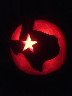 a red pumpkin with a white star carved into it