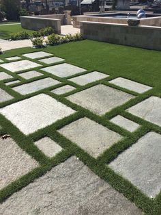 an outdoor area with grass and stepping stones