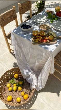 the table is set with plates and bowls of fruit