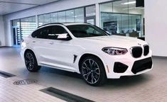 a white bmw suv is parked in a showroom