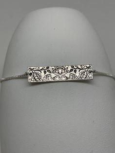 This boho lotus flower bar bracelet has been handmade using .925 sterling silver. It has been cut from sterling silver precious metal clay, textured, fired and oxidized. The bracelet is connected with 1mm sterling silver box chain and finished with a slider bead and two sterling silver ball stoppers. This sterling silver bracelet features a reversible embossed floral lotus printed textured pattern. Bracelet connector size: approximately 1 1/8 x 1/4 inches Bracelet length: can choose a stock leng Silver Bar Bracelet, Lotus Print, Bar Bracelet, Precious Metal Clay, Floral Bracelet, Silver Bar, Bracelet Boho, Bar Bracelets, Bracelet Sterling Silver