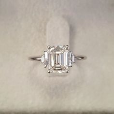 an emerald cut diamond ring with three baguets