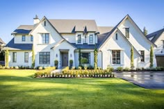 a large white house sitting on top of a lush green field