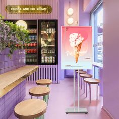 an ice cream shop with purple walls and wooden stools in front of the counter