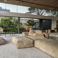 a living room with couches and chairs in front of large windows overlooking the mountains