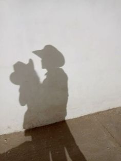 a shadow of a person with a hat on