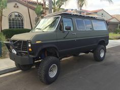 an suv is parked in front of a house with palm trees on the side walk