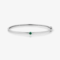 A timeless gold bangle showcases a solitary emerald at its center, infusing elegance with a touch of brilliance. Single Stone, Gold Bangle, Gold Bangles, Emerald, Bangles, White Gold, Yellow Gold, Stone, Yellow