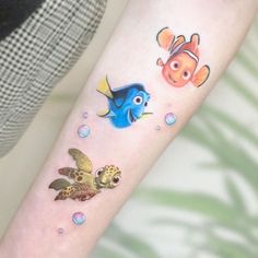 a woman with a tattoo on her arm has an image of two fish and a turtle