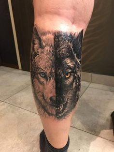 a man's leg with two wolfs on it, one is black and white