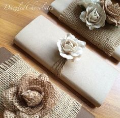 three pieces of cloth with flowers on them sitting on a wooden table next to each other