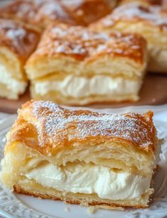 two slices of pastry sitting on top of a plate next to another piece of cake