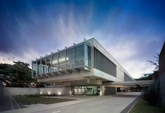 the building is made of concrete and has glass windows on it's sides, along with stairs leading up to the second floor