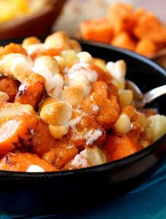 a bowl filled with food sitting on top of a blue table cloth next to other foods