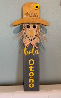 a wooden scarecrow with a hat on it's head and the word hola otro