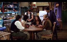 the cast of friends are gathered around a table