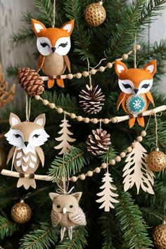 an ornament hanging from a christmas tree decorated with pine cones and woodland animals