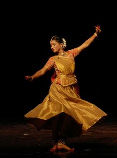 a woman in a yellow dress dancing on stage