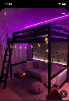 a loft bed with purple lighting in the corner and a futon sofa underneath it