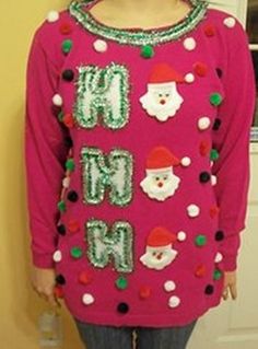 a woman standing in front of a door wearing a pink sweater with santa clause on it