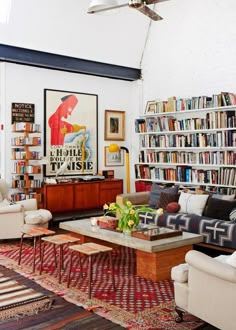 a living room filled with lots of furniture and bookshelves full of books on shelves