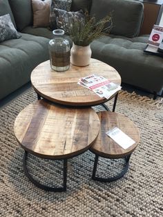 three wooden tables sitting on top of a rug in front of a couch and coffee table