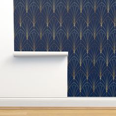 an empty room with a blue wallpaper and gold art deco pattern on the wall