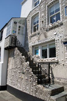 the building has many windows and balconies on it's sides, along with an iron stair case