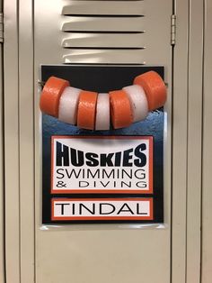 an orange and white necklace hanging from the side of a locker