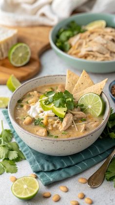 two bowls filled with chicken tortilla soup and garnished with cilantro