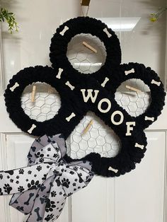 a door hanger that says woof with dog paws and bones on it