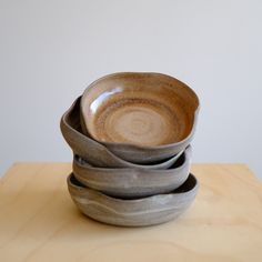 a stack of bowls sitting on top of a wooden table