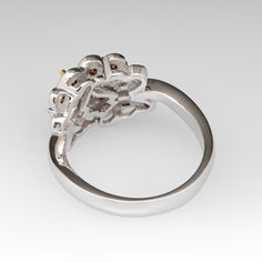 a white gold and diamond ring with flowers on the front, set in 18k white gold