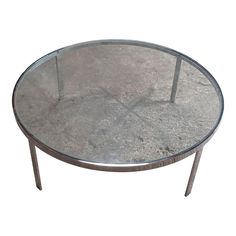 a round glass table with metal legs on an isolated white background for use as a coffee table