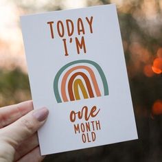 someone holding up a card with the words today i'm one month old on it