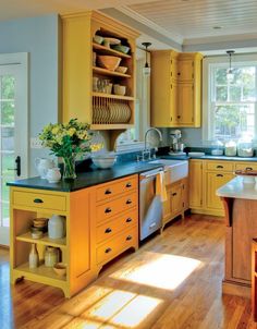 a large kitchen with yellow cabinets and wooden floors is pictured in this image from the inside