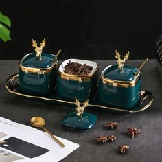 three pieces of green ceramic with gold trimmings and decorative decorations on the tray